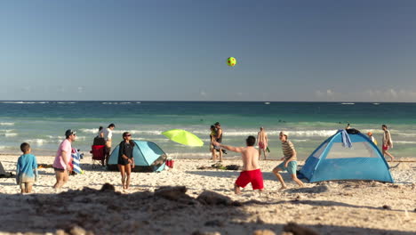 Family-enjoying-sunny-summer-day-on-mexican-beach,-playing-volleyball