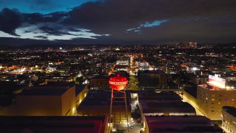 Sony-Pictures-Studio-Berühmter-Wasserturm-Bei-Nacht-–-Aufsteigende-Luftaufnahme-Der-Stadt