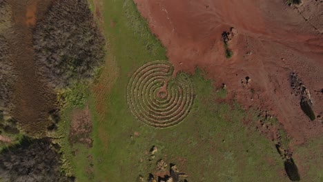 Concentric-circle-stone-pattern-on-binimel-la-beach-menorca-spain-in-red-dirt-earth