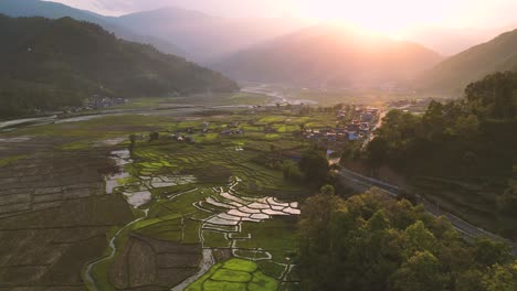 Vista-De-Pájaro-De-Las-Plantaciones-De-Arroz-Que-Reflejan-El-Cielo-En-Una-Puesta-De-Sol-Dorada---Zona-Rural-De-Pokhara,-Nepal