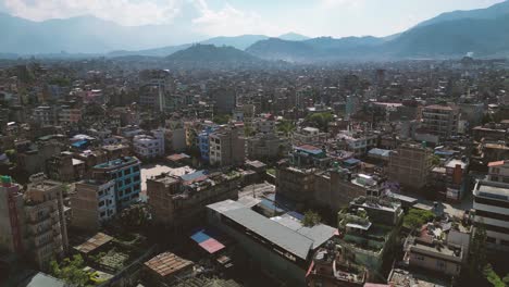 Vista-De-Pájaro-De-La-Ciudad-De-Katmandú-Y-Sus-Edificios-Con-Una-Cadena-De-Montañas-En-El-Fondo---Nepal