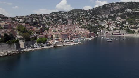 Villefranche-sur-Mer-Resort-down-on-Cote-d'Azur-French-Riviera-Coastline,-Aerial-Drone-Establishing-Shot