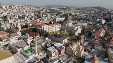 Mosques-and-churches-in-old-town-Nazareth,-Israel:-Low-aerial-orbit