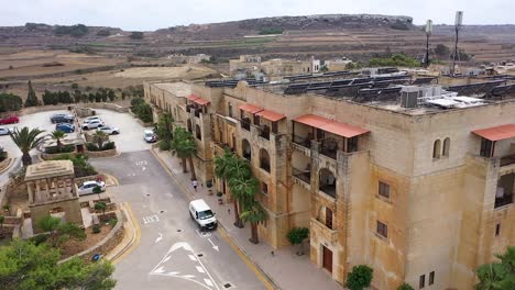 Aerial-view-of-Gozo,-a-Maltese-island,-and-the-area-surrounding-a-hotel-complex