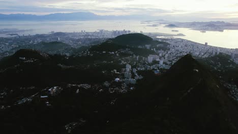 Aerial-view-over-mountains-overlooking-the-city-of-Rio-de-Janeiro,-colorful-dusk-in-Brazil