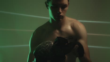 Muscular-Man-Putting-On-Boxing-Gloves.-medium-shot