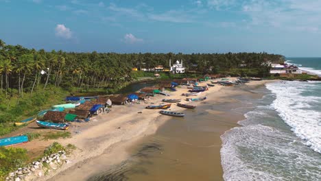 aerial-view-of-fishing-village-with-many-boats-moored-on-the-beach-sand---Varkala,-Kerala,-South-India