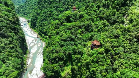 Aerial-top-down-shot-of-temple-surrounded-by-deep-forest-woodland-in-park-during-sunlight---Taroko-Nationalpark,-Taiwan
