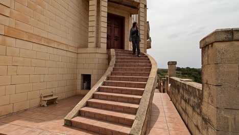 Woman-walking-down-stairs-sandstone-building