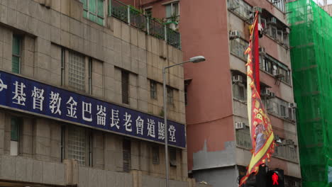 Static-medium-shot-of-sign-in-chinese-outside-building-with-banner-flag-flying