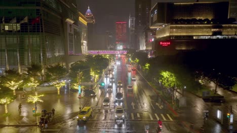 Aerial-establishing-drone-shot-of-traffic-on-road-in-Taipei-City-during-rainy-day-at-night-in-Christmas-Season---Lighting-and-decorated-trees-in-Asian-town