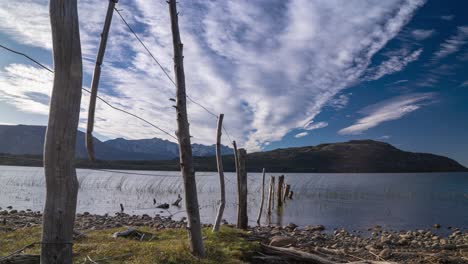 Timelapse-of-serene-lake-lezana,-fast-moving-clouds-against-mountain-backdrop