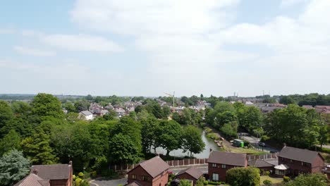 Suburban-woodland-red-brick-British-townhouse-development-neighbourhood-aerial-view-above-detached-property