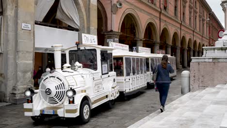 Ferrara-City-Tourist-Train-Passing-Through-Piazza-Maggiore-In-Bologna