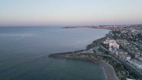 Aerial-drone-view-of-Sao-Pedro-do-Estoril-Beach-in-Sao-Pedro-do-Estoril-with-Cascais-in-background,-Portugal