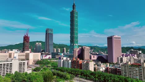 Toma-Aérea-Acercándose-A-La-Torre-101-En-La-Ciudad-De-Taipei-Durante-Un-Día-Soleado-Con-Cielo-Azul---Estableciendo-Vuelo