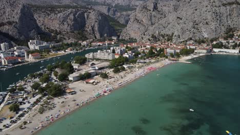 Luftaufnahme-Des-Strandes-Velika-Plaza-In-Omis,-Kroatien-Vor-Schroffen-Bergen-Zwischen-Der-Mündung-Des-Flusses-Cetina-Und-Der-Adria