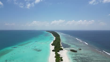 Aerial-dolly-in-above-Dhigurah-Island,-lush-long-white-sand-beach-and-clear-tropical-turquoise-water,-Maldives