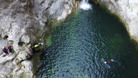 Canyoneer-people-canyoning-and-cliff-jumping-head-first-at-Gubavica-Waterfall-in-omis,-Croatia