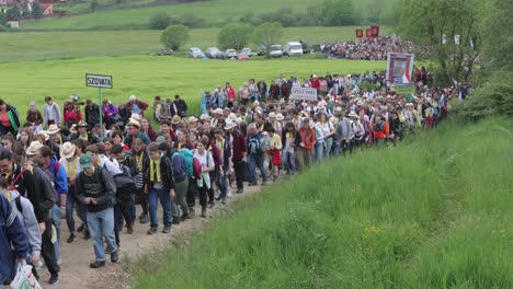 Large-crowd-slowly-walking-up-dirt-path-in-Romania,-on-Csíksomlyó-Pilgrimage