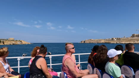 Shot-of-tourists-sitting-on-a-sightseeing-boat-while-traveling-while-touring-Malta-on-a-bright-sunny-day