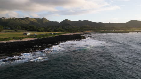 A-drone-pans-and-rotates-during-golden-hour-at-Sandy-Beach-in-Oahu,-Hawaii