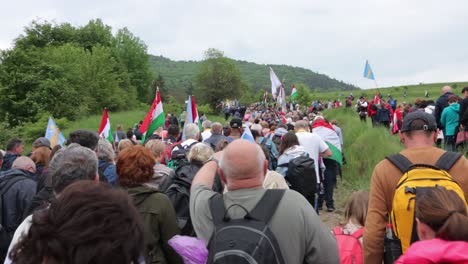 POV-among-crowd-of-people-on-Csíksomlyó-Pilgrimage-carrying-Hungarian,-Szekler-flags