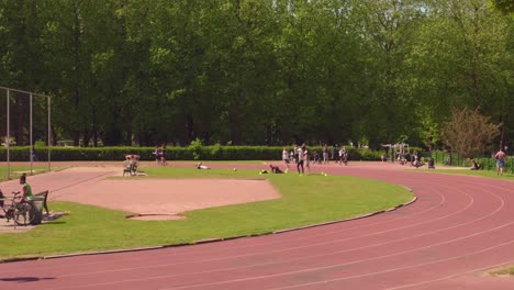 Lugareños-Corriendo-Alrededor-De-Una-Pista-De-Atletismo-En-El-Parque-Cincuentenario-En-Bruselas,-Bélgica-Durante-El-Día