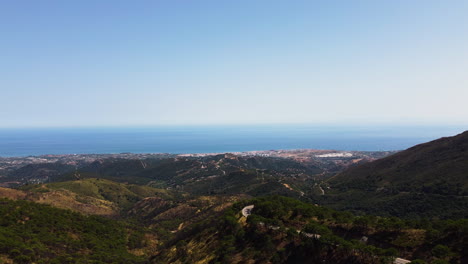 Eine-Drohne-Schiebt-Sich-über-Bergbäume-Und-Zeigt-Eine-Luftaufnahme-Der-Küste-In-Der-Nähe-Von-Estepona,-Spanien