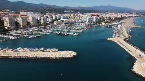 A-drone-rotates-over-the-harbor-and-waterfront-of-Estepona,-Spain