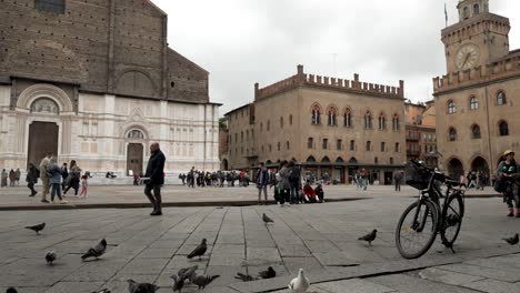 Low-angle-wide-shot-of-tourists-exploring-square-around-Basilica-of-San-Petronio