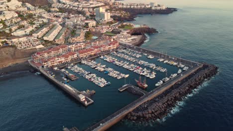 Huge-pier-with-boats-and-iconic-cityscape-of-Tenerife-island,-aerial-view