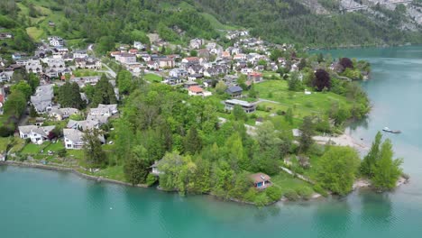 Wunderschöne-Luftaufnahme-Eines-Dorfes-In-Der-Schweiz,-Eingebettet-In-Grün-Und-See