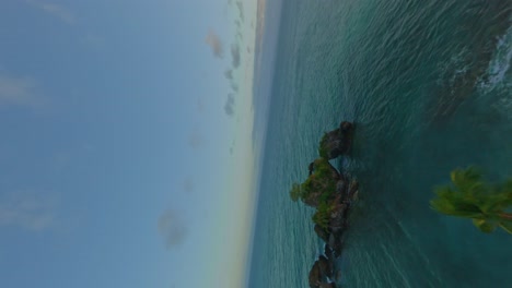 Vertical-drone-flight-along-coastline-and-island-with-tropical-palm-trees-during-dusk---Dynamic-fpv-in-Samana,-Dominican-Republic