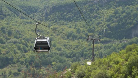Empty-Dajti-cable-car-goes-down-forest-mountain-side-in-Albania