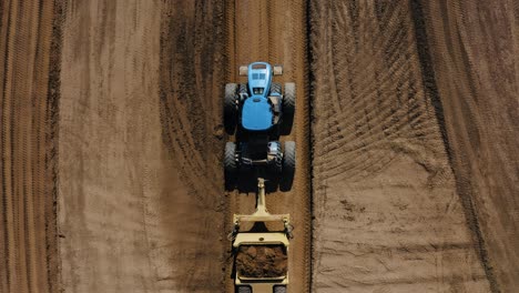 Overhead-drone-shot-of-a-tractor-towing-loads-of-dirt