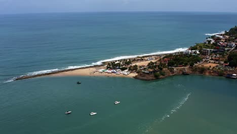 Dolly-In-Nach-Unten-Geneigter-Luftaufnahme-Einer-Drohne,-Die-Sich-Bei-Flut-Dem-Berühmten-Tropischen-Strand-Tibau-Do-Sul-Nähert,-Mit-Touristen,-Die-Unter-Bunten-Sonnenschirmen-In-Rio-Grande-Do-Norte,-Brasilien,-Schwimmen-Und-Schatten-Genießen