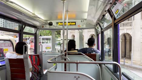 Passengers-ride-double-decker-tram-in-downtown-of-Hong-Kong,-inside-view