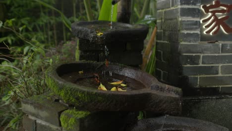 Stylized-fountain-with-water-dripping-down-over-stone-waterway