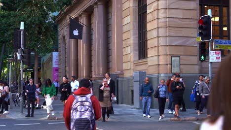 Large-crowds-of-people-crossing-the-road-at-the-corner-of-Queen-and-Edward-street-during-rush-hours,-with-Brisbane-Apple-flagship-store-in-the-heritage-listed-MacArthur-Chambers-in-the-background