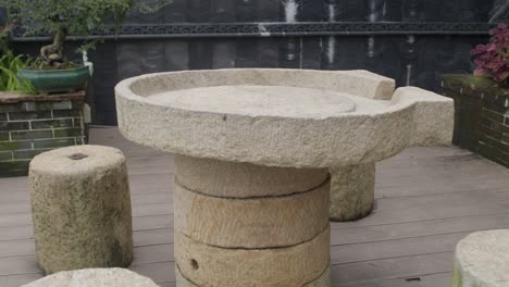 Stilisierter-Steintisch-Und-Steinsitze-In-Einem-Garten-Im-Asiatischen-Stil