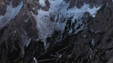 Drone-shot-over-a-rocky-ridge,-revealing-the-Cadini-di-Misurina-mountains,-in-Dolomites,-Italy
