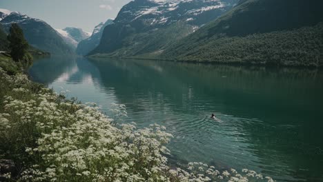 Person-swimming-in-lake-Lovatnet,-calming-and-relaxing-experience