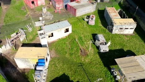 Paintball-Action-Park-With-Old-Shipping-Containers-And-Vehicles-In-Pachfurth,-Austria---aerial-drone-shot