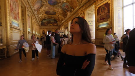 Beautiful-elegant-young-woman,-looking-at-the-ceiling-of-a-gold-decorated-corridor,-in-the-Louvre-Museum,-Paris,-France