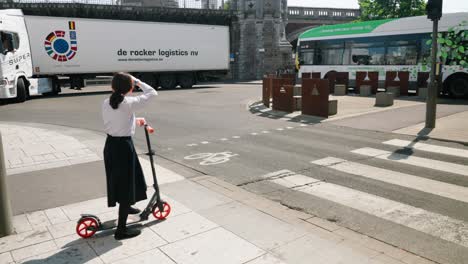 Girl-sees-danger-of-big-truck-bending-at-the-intersection-in-the-city-center-as-she-steps-back-for-safety---Concept-of-traffic-accident,-urban-mobility,-protection---Antwerp,-Belgium
