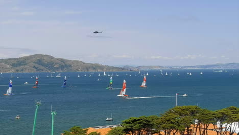 Viele-Segelboote-Rasen-Während-Des-Segelwettbewerbs-Mit-Darüber-Fliegendem-Hubschrauber