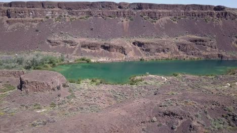 Aerial-descends-to-vivid-green-of-Deep-Lake-cliffs-in-WA-Scablands