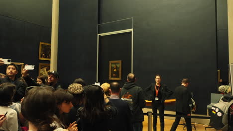 Crowd-of-people-looking-at-the-famous-Gioconda,-Monalisa-painting,-by-Leonardo-Da-Vinci,-in-the-Louvre-Museum,-France