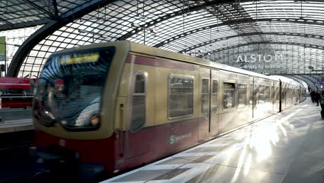 S-Bahn-Serie-481-Bei-Der-Ankunft-Auf-Dem-Oberen-Bahnsteig-Am-Berliner-Hauptbahnhof-Mit-Sonnenlicht,-Das-Vom-Glasdach-Auf-Den-Zug-Reflektiert-Wird